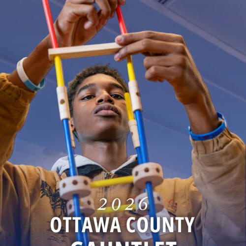 Student participating in a hands-on building exercise for the 2026 Ottawa County Gauntlet at Seidman College of Business.